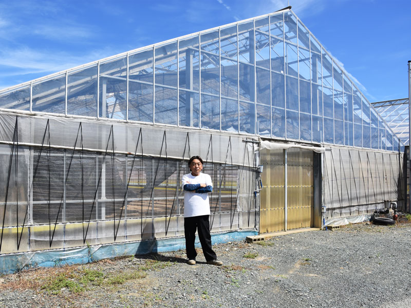 栽培ハウス前に立つ富永さん