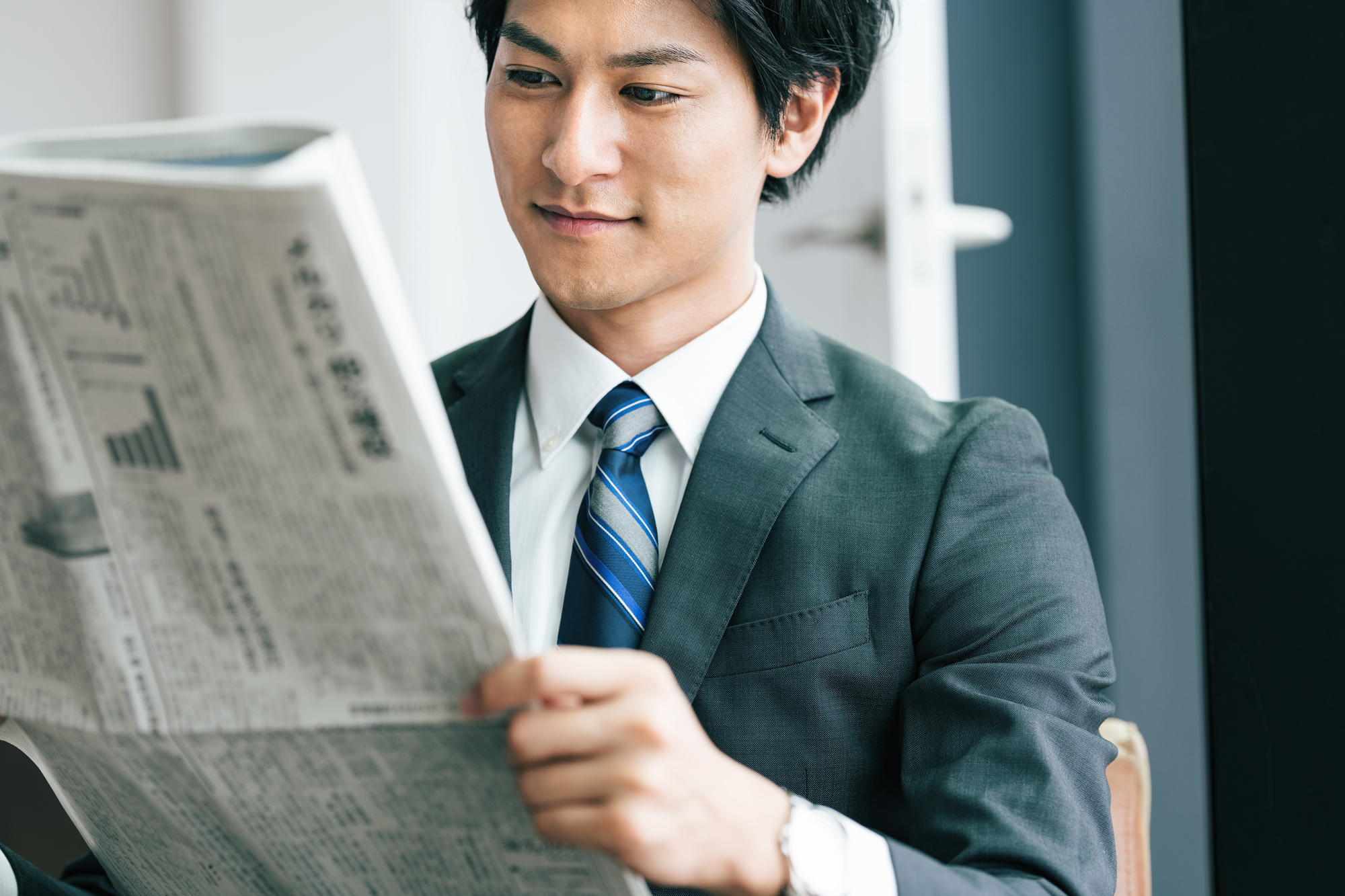 新聞を読む社会人男性